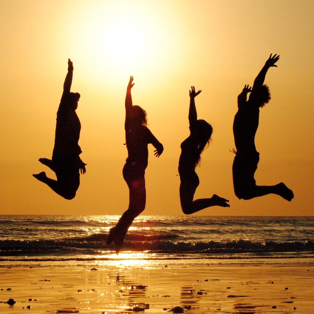 Sunset friends jumping in the air