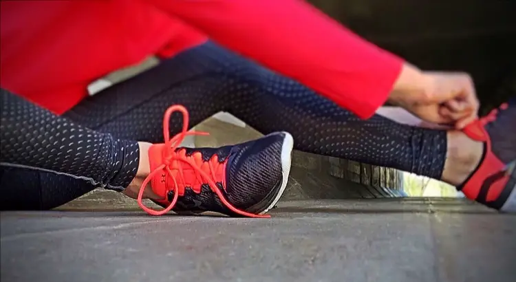 Person putting running shoes on getting ready for a workout